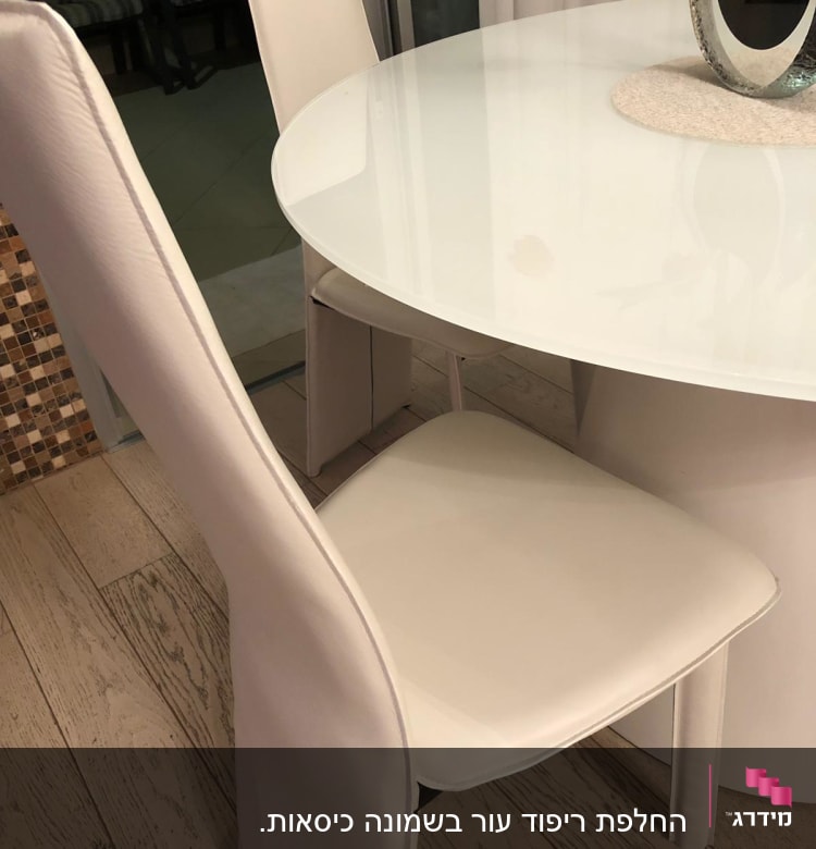 כיסאות מרופדים בלבן ליד שולחן עגול